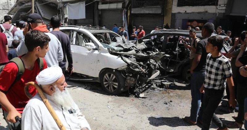 يتفقد فلسطينيون موقع غارة إسرائيلية استهدفت مركبة في حي الرمال بمدينة غزة