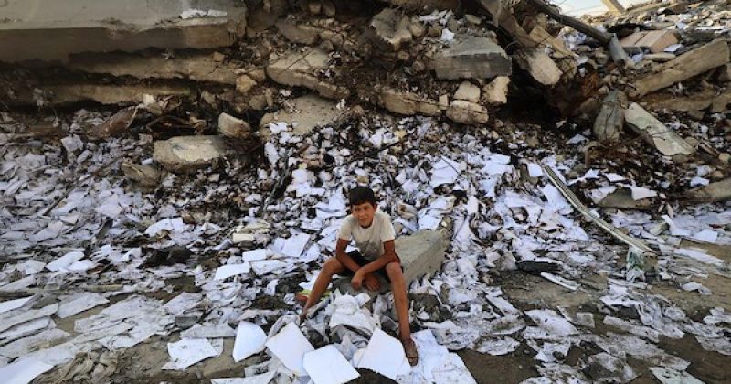 فلسطينيون يتفقدون الأضرار التي لحقت بمبنى إثر غارة جوية إسرائيلية على شارع الجلاء وسط مدينة غزة