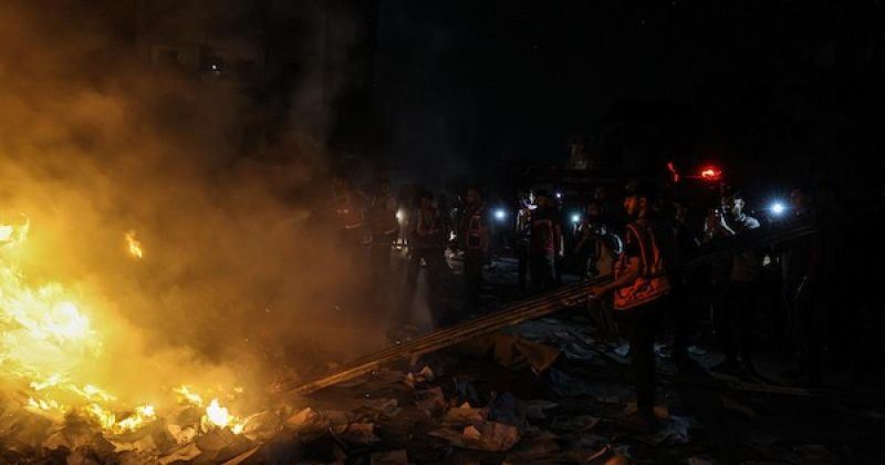 فلسطينيون يتفقدون الأضرار التي لحقت بمبنى إثر غارة جوية إسرائيلية على شارع الجلاء بمدينة غزة
