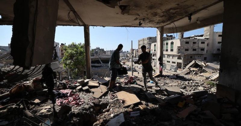 فلسطينيون يتفقدون الأضرار التي لحقت بأحد المنازل عقب غارة إسرائيلية على غزة
