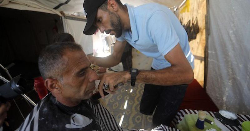 من خيمة النزوح.. حلاق فلسطيني يواصل العمل بعد فقدان ساقه في غزة