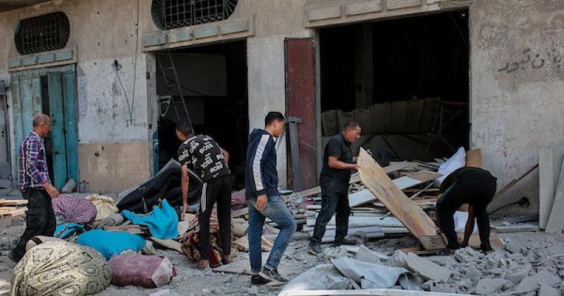 يتفقد فلسطينيون الأضرار التي لحقت بمنزل في حي التفاح  عقب غارة إسرائيلية