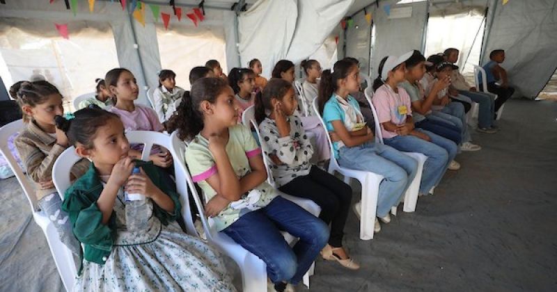 طلاب فلسطينيون درساً داخل خيمة في مخيم البريج