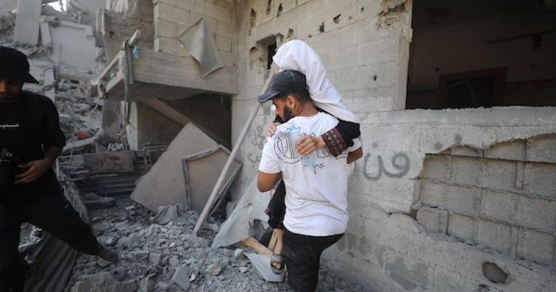 فلسطينيون يتفقدون مبنىً دُمر في غارة جوية إسرائيلية بمخيم النصيرات