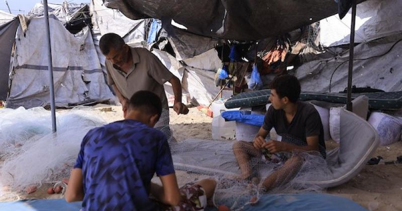 من بين أنقاض منزله في غزة.. صياد فلسطيني يرمم شباكه بحثًا عن رزق أطفاله